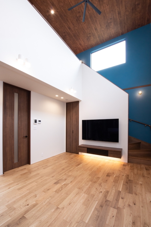 ブルーのクロスが印象的な階段と吹き抜けがつなぐ空間