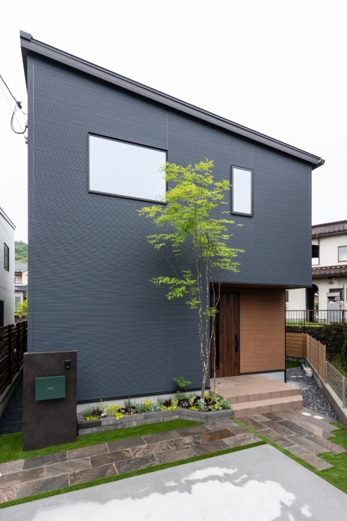 片流れ屋根と木目調玄関が映えるスタイリッシュな外観