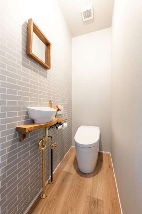 カフェ風レンガ調クロスと造作手洗いのトイレ