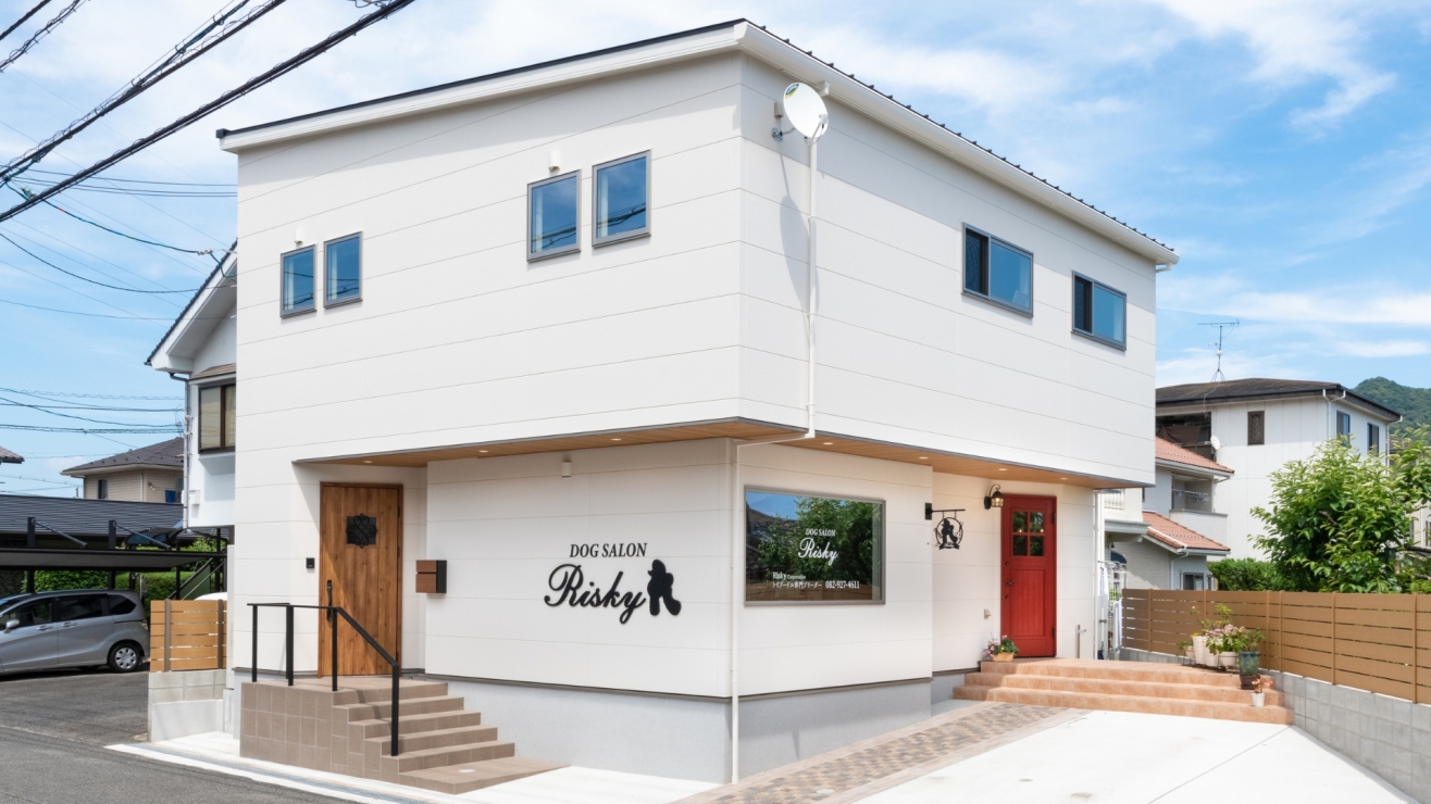 赤い扉が映えるドッグラン併設の店舗併用デザイン住宅